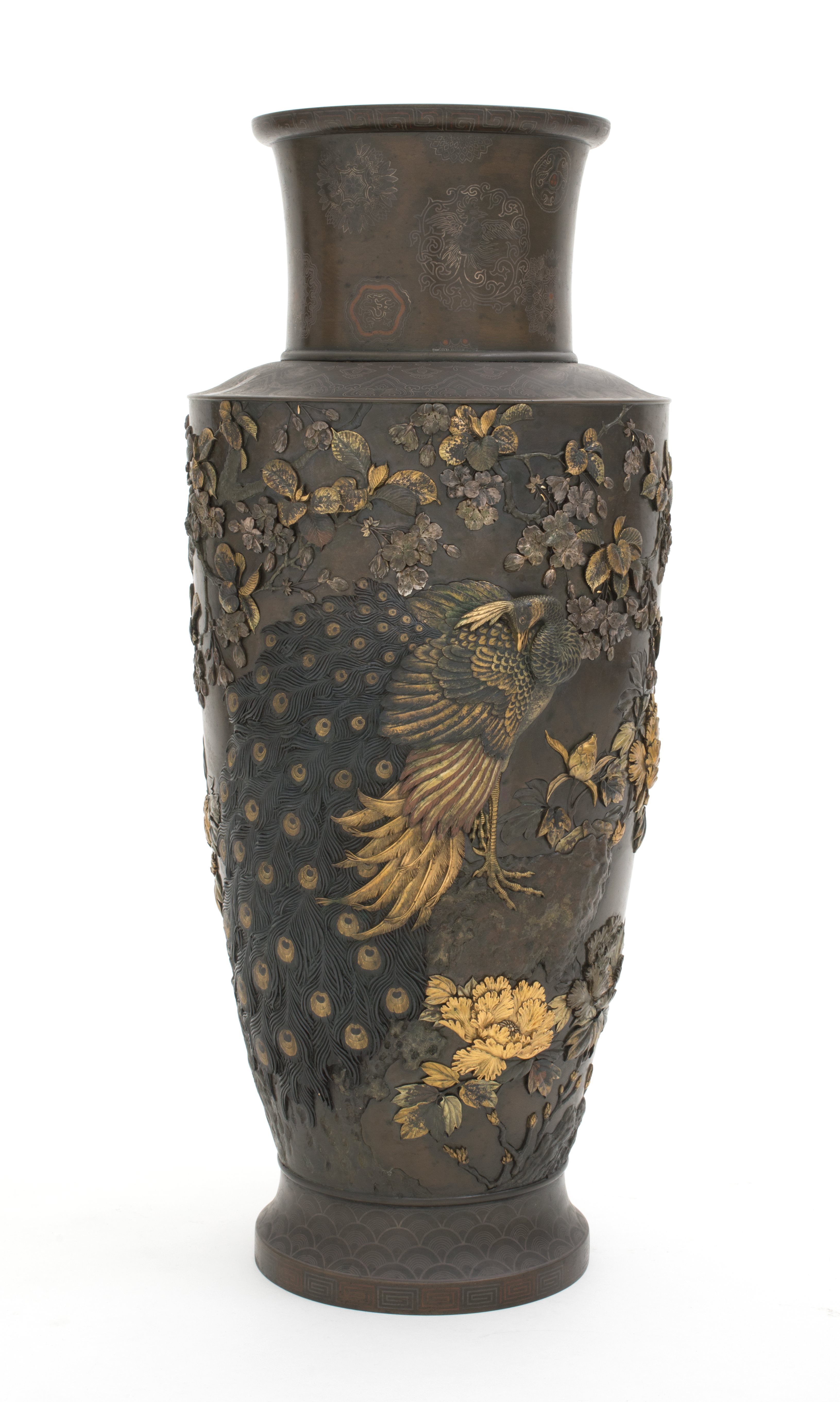 Bronze vase with a single peacock in the centre with foliage and pink tinged blossoms overhead and the golden peony underneath.